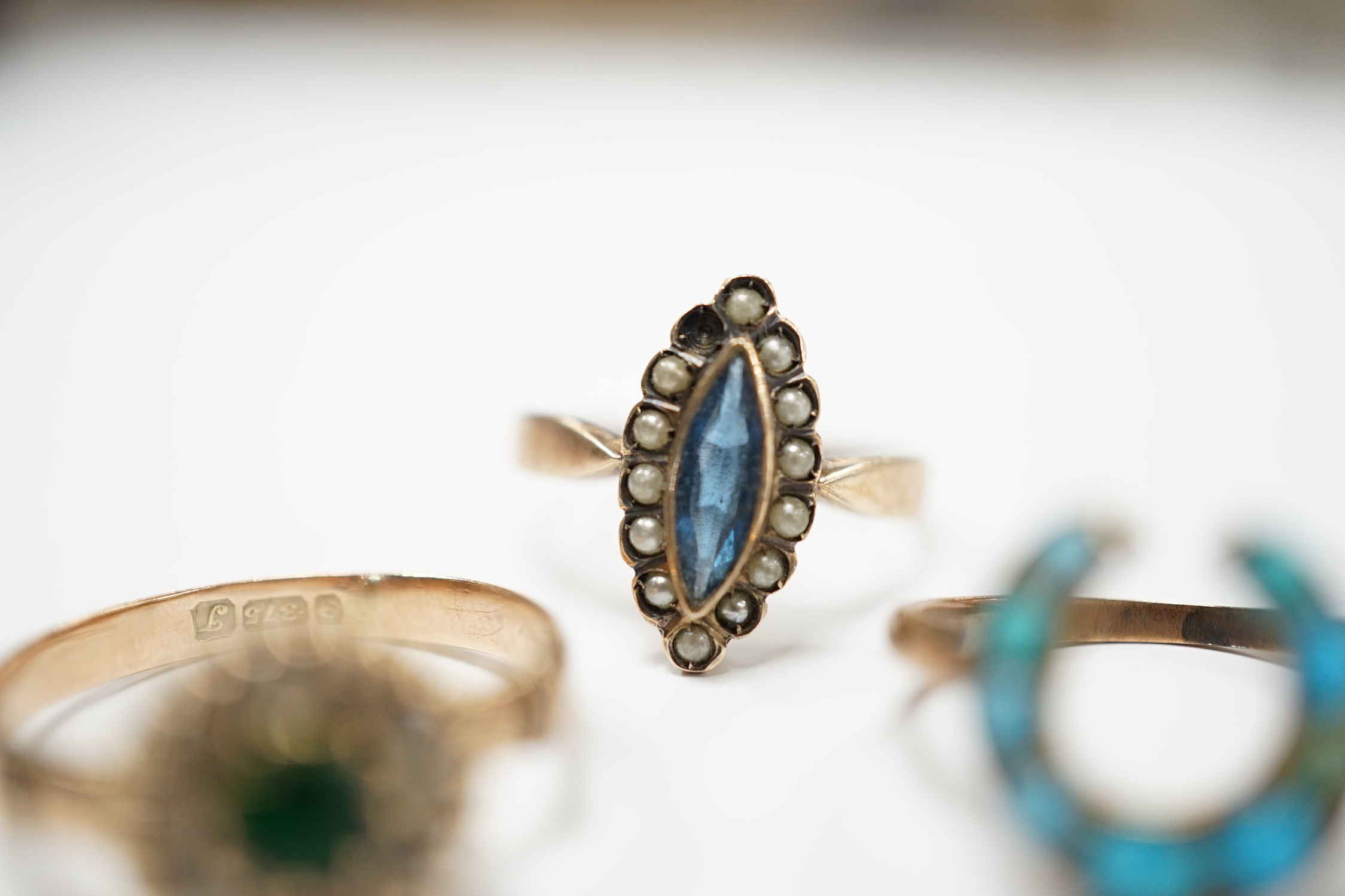 An early 20th century 9ct gold and two colour pastes set circular cluster ring, a 333 (8ct) ring and one other yellow metal and turquoise set horseshoe ring, gross weight 5.6 grams.